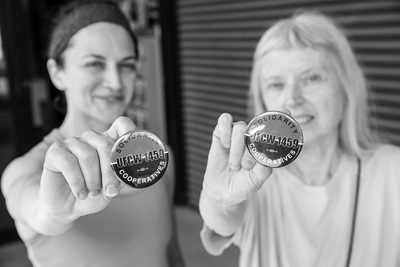 Erin Merrigan, left, and Karen Kane show off buttons supporting a labor union at Wild Oats Market. Workers at the food co-op in Williamstown voted to unionize in February 2016, but the union and management have yet to negotiate a labor contract. Scott Langley photo