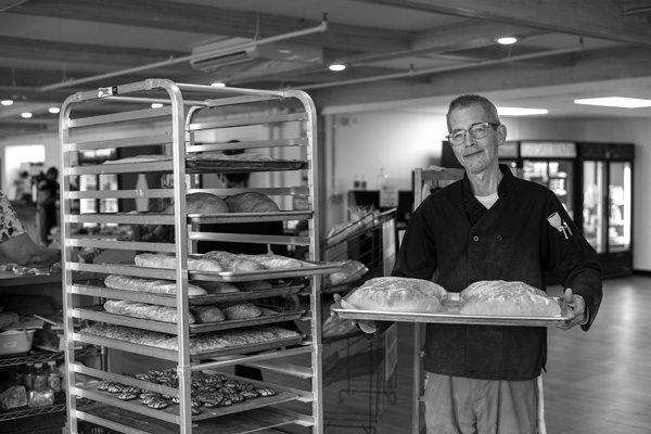 Head baker Shayne Williams holds a tray of freshly baked loaves of bread at the new Bennington Community Market. Joan K. Lentini photo