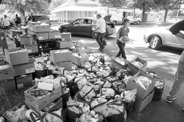

Volunteers at a food distribution event load boxes and bags into cars that formed a long line last month at the Columbia County Fairgrounds. Photo by Scott Langley