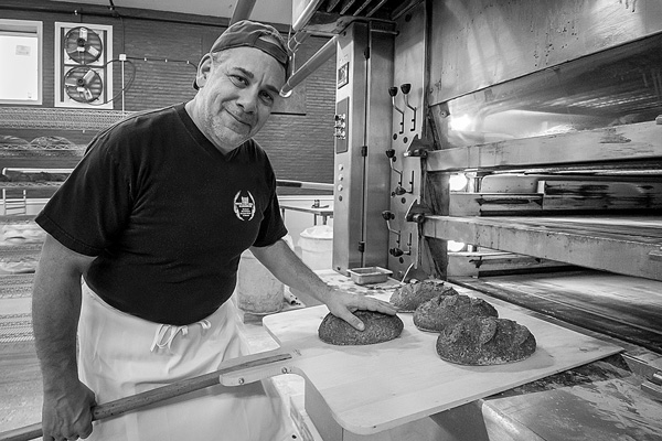 Matt Funiciello, the owner of Rock Hill Bakehouse, removes several loaves of bread from the oven at the bakery’s new home in the Shirt Factory complex in Glens Falls. Joan K. Lentini photo